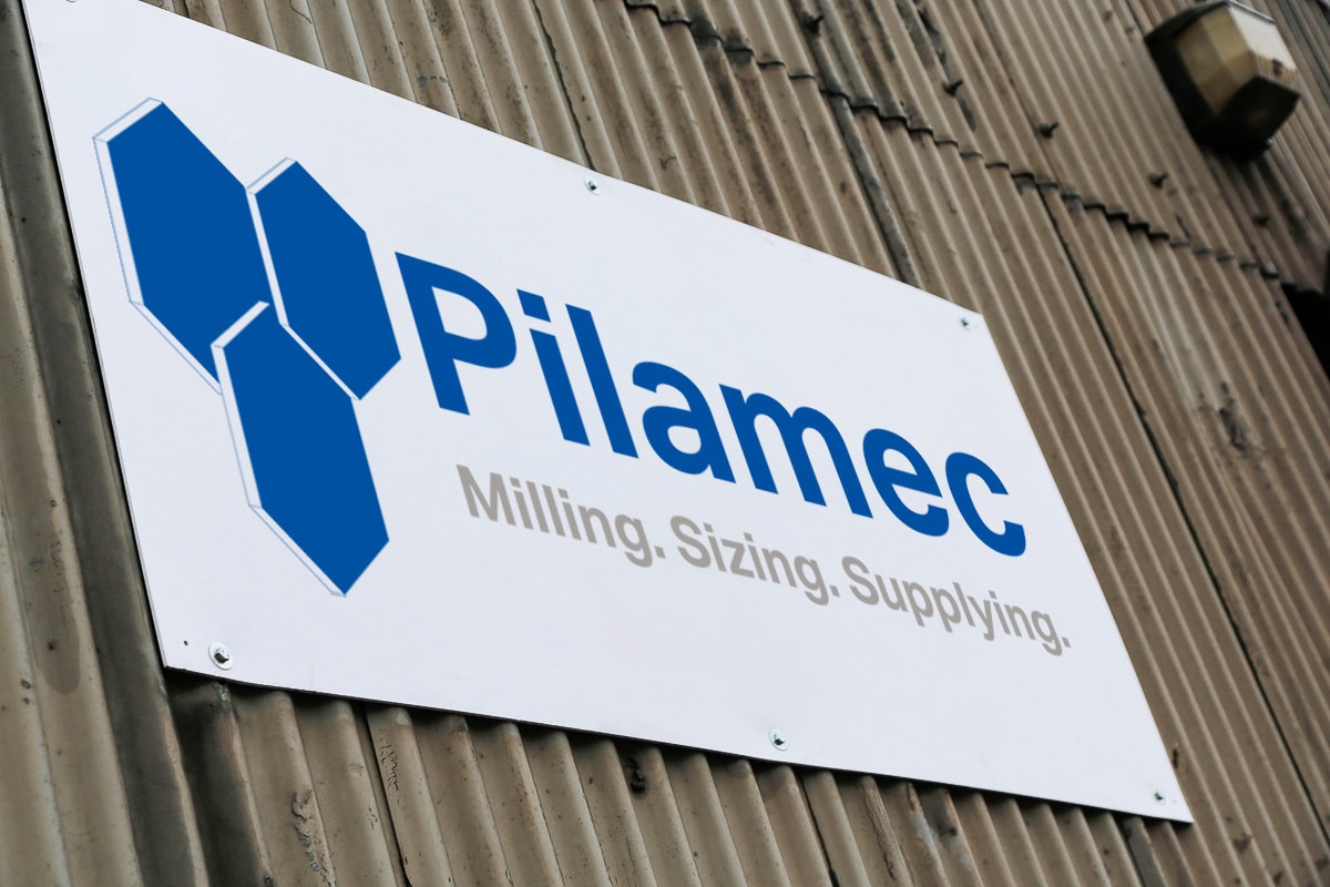 The Pilamec logo on a sign attached to a wall.